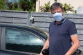 Man in hande made medical mask respirator gets out of van car during coronavirus epidemic covid-19 Royalty Free Stock Photo