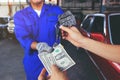 Man handed the money to Car mechanic holding in a hand car keys Royalty Free Stock Photo