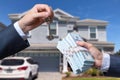 Man Handing a man Thousands of Dollars For Keys in Front of House. Royalty Free Stock Photo