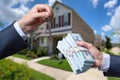 Man Handing a man Thousands of Dollars For Keys in Front of House. Royalty Free Stock Photo