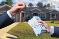 Man Handing a man Thousands of Dollars For Keys in Front of House. Royalty Free Stock Photo