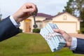 Man Handing a man Thousands of Dollars For Keys in Front of House. Royalty Free Stock Photo