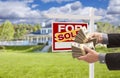 Man Handing Over Money in Front Sold House and Sign Royalty Free Stock Photo