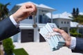 Man Handing a man Thousands of Dollars For Keys in Front of House. Royalty Free Stock Photo