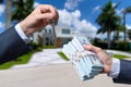 Man Handing a man Thousands of Dollars For Keys in Front of House. Royalty Free Stock Photo