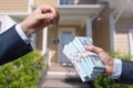 Man Handing a man Thousands of Dollars For Keys in Front of House. Royalty Free Stock Photo