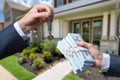 Man Handing a man Thousands of Dollars For Keys in Front of House. Royalty Free Stock Photo