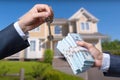 Man Handing a man Thousands of Dollars For Keys in Front of House. Royalty Free Stock Photo