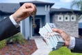 Man Handing a man Thousands of Dollars For Keys in Front of House. Royalty Free Stock Photo