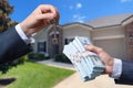 Man Handing a man Thousands of Dollars For Keys in Front of House. Royalty Free Stock Photo