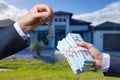 Man Handing a man Thousands of Dollars For Keys in Front of House. Royalty Free Stock Photo