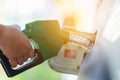 Man Handle pumping gasoline fuel nozzle to refuel. Vehicle fueling facility at petrol station. White car at gas station being Royalty Free Stock Photo