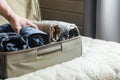 A man handles things. Open suitcase with clothes on the bed. View to the bedroom. Royalty Free Stock Photo
