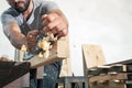 Man handles a wooden bar with a black jack plane Royalty Free Stock Photo