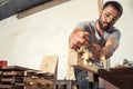 Man handles a wooden bar with a black jack plane Royalty Free Stock Photo