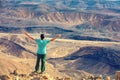 A man standing on the cliff in the desert