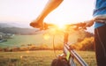 Man hands on the bike steering wheel close up image. Man with bike stay on the top of hill and enjoying the sunset Royalty Free Stock Photo