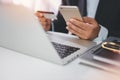 Man hands in black suit sitting and holding credit card and using laptop computer on table for online payment or shopping online. Royalty Free Stock Photo