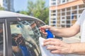 Man hands cleaning and spaying car exterior. Shit bird dropping on car window