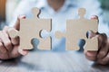 Man hands connecting couple puzzle over table, businessman holding wood jigsaw inside office. Business solutions, mission, target Royalty Free Stock Photo