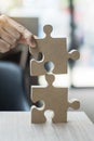 Man hands connecting couple puzzle over table, businessman holding wood jigsaw inside office. Business solutions, mission, target Royalty Free Stock Photo
