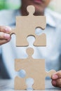 Man hands connecting couple puzzle over table, businessman holding wood jigsaw inside office. Business solutions, mission, target Royalty Free Stock Photo