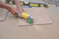 Man hands cutting a tile using an angle grinder on the floor Royalty Free Stock Photo