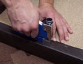 Man hands fastening leather to the paricle board using stapler.
