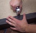 Man hands fastening leather to the particle board using stapler