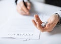 Man hands with gambling dices signing contract Royalty Free Stock Photo