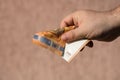 Man hands giving money like a bribe or tips. Holding EURO banknotes on a blurred background, EU currency Royalty Free Stock Photo