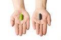 Man hands giving two big pills. Green and black. Make your selection. health or death. Choose your side