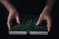 Man hands hold a green computer board with a chip on a black backgr Royalty Free Stock Photo