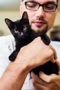 Man hands holding a black baby cat Royalty Free Stock Photo