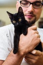 Man hands holding a black baby cat Royalty Free Stock Photo