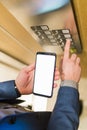 Man hands holding blank screen mobile phone while using elevator control panel Royalty Free Stock Photo