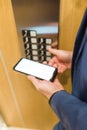 Man hands holding blank screen mobile phone while using elevator control panel Royalty Free Stock Photo