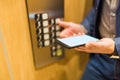 Close up of businessman using blank screen smartphone and pressing elevator button. Business and office building meeting concept Royalty Free Stock Photo