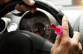 Man`s hands holding a candy and the steering wheel of the car Royalty Free Stock Photo