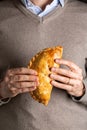 Man hands holding cornish pasty, meat turnover or pie, with filling, beef Royalty Free Stock Photo