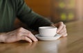 Man hands holding cup of coffee, cafe interior Royalty Free Stock Photo