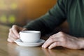 Man hands holding cup of coffee, cafe interior Royalty Free Stock Photo
