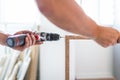 Man hands holding electrical screwdriver while assembling kitchen wooden elements Royalty Free Stock Photo