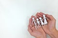 Man hands holding a family paper cutout in white background. Family care, protection and planning Royalty Free Stock Photo