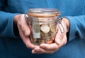 Man hands holding jar full of euro money, pension fund concept, coins and banknotes