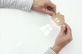 Man hands holding paper house, light through the window Royalty Free Stock Photo