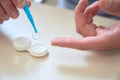 Man hands holding sterile eye lenses with tweezer above the table Royalty Free Stock Photo