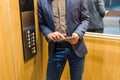 Man hands holding tablet device next to elevator control panel