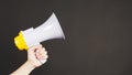 Man hands is holding yellow megaphone on black background