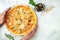 man hands holds pizza with salmon and mussels on a light background, Mediterranean cuisine, Restaurant menu, dieting, cookbook